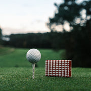 Red golf tee match box by Three Putt Round, featuring a collection of standard wooden golf tees inside a compact, portable container.