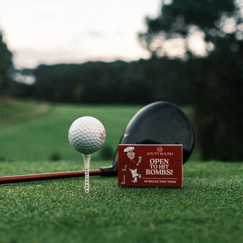 Set of red golf tees in a matchbox by Three Putt Round, compact golf tee holder with multiple tees inside.